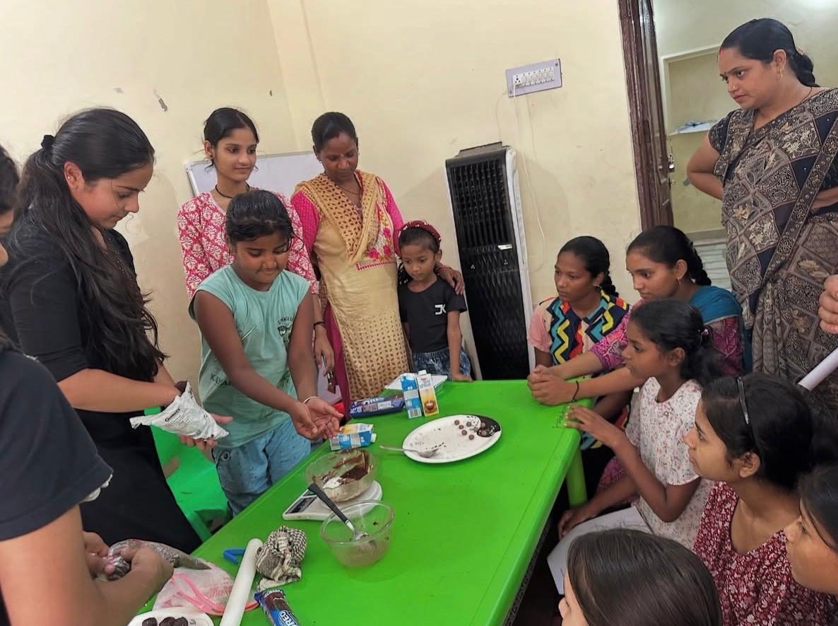 ASOS members teaching children to bake around a green table