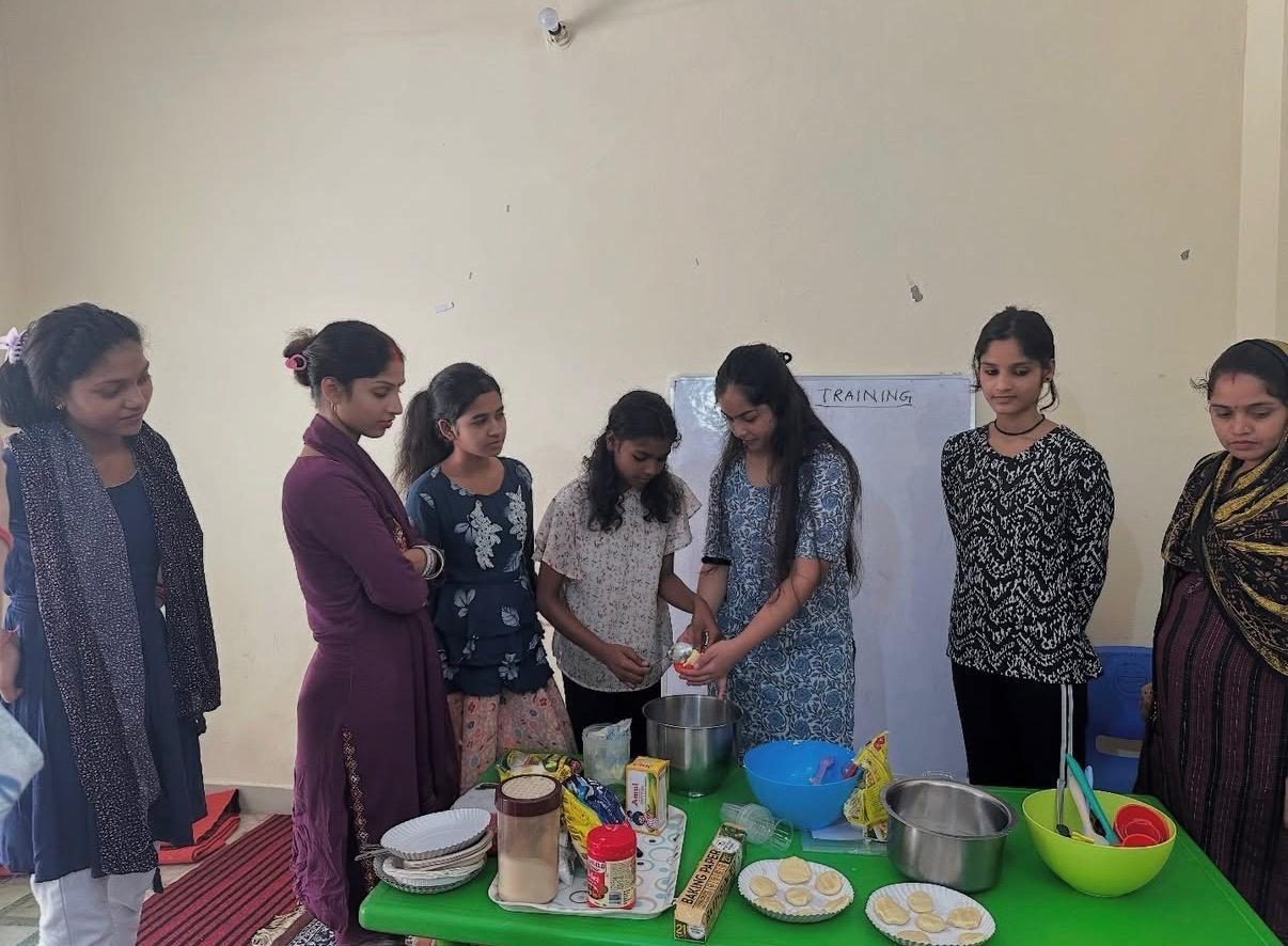 Women at a weekly ASOS baking session with ingredients laid out on a table