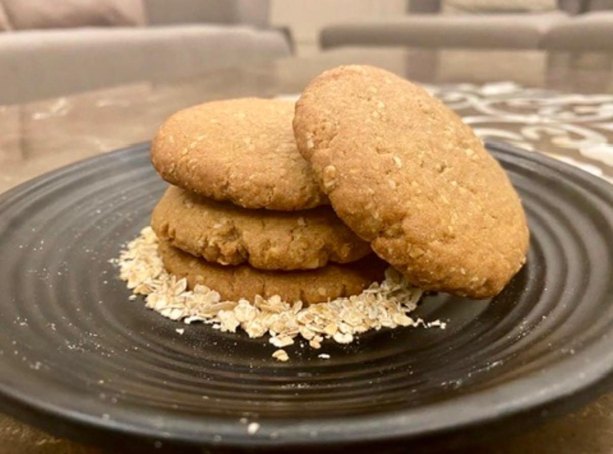 A stack of oat cookies on a dark plate